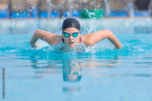Young girl swimming butterfly stroke style