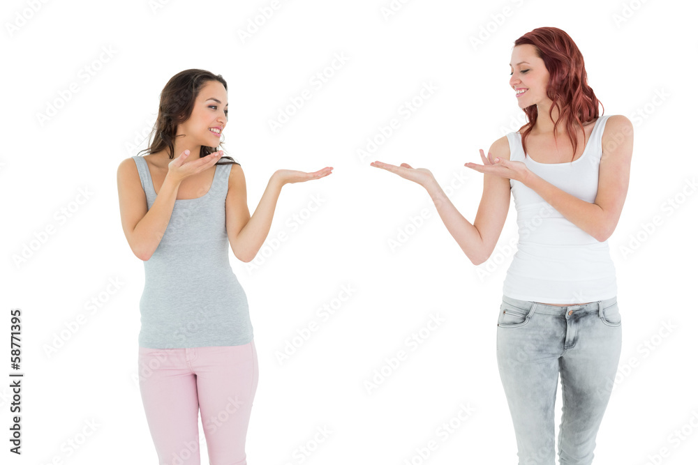 Two happy young female friends holding out their hands Two happy young female friends holding out their hands