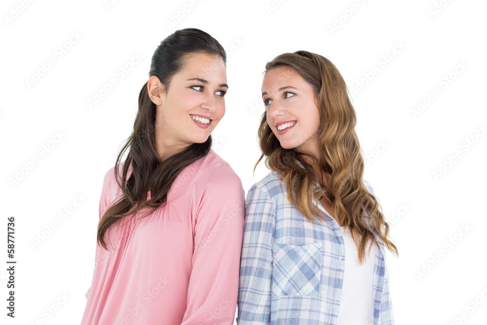 Happy young female friends standing back to back Happy young female friends standing back to back