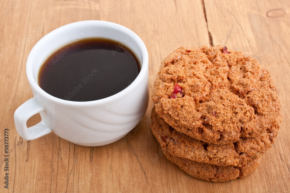pile of cookies and a cup of coffee on a wooden table