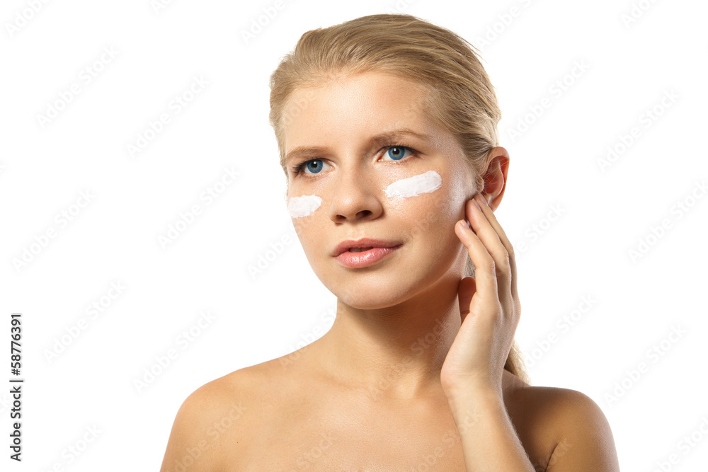 Woman applying moisturizer cream on face isolated