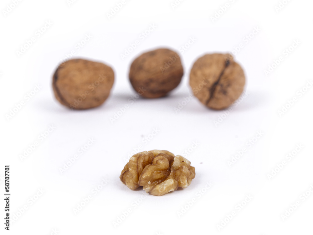 Peeled walnut with closed nutshells behind it