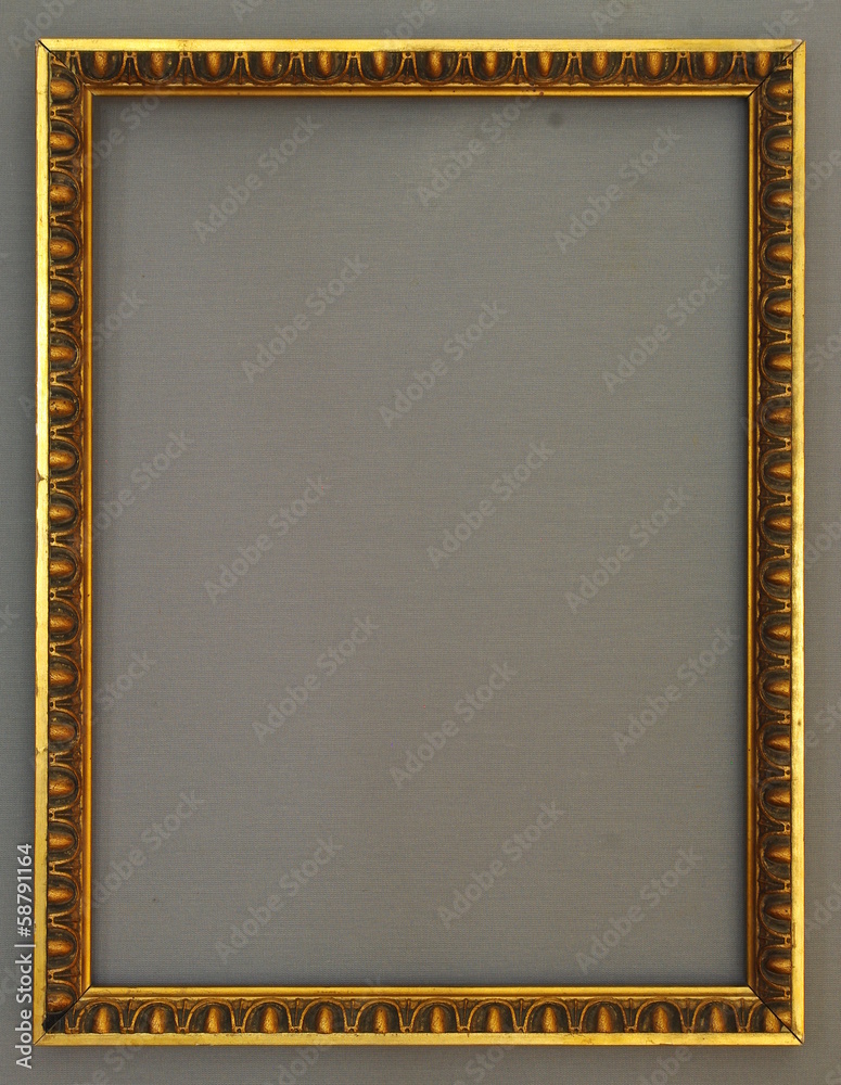 Fototapeta premium Verzierter goldener Bilderrahmen vor grauem Hintergrund