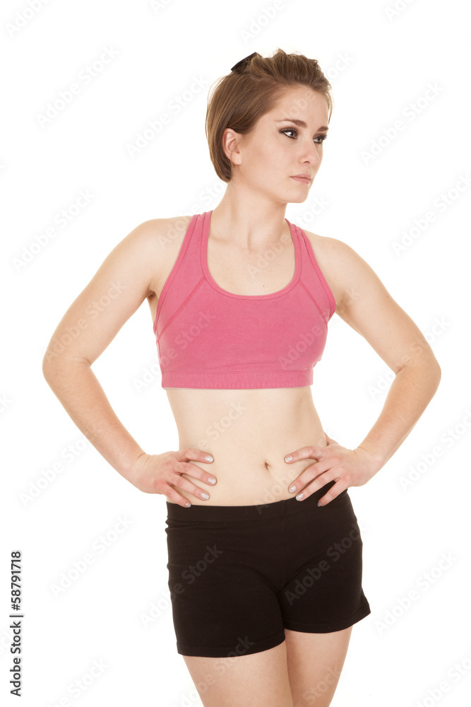 woman in a pink bra hands hips look side serious