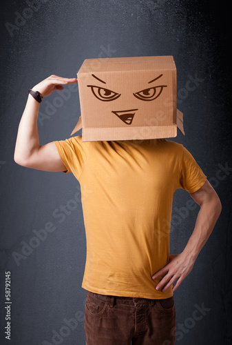 Young man gesturing with a cardboard box on his head with evil f