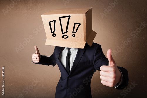 Businessman gesturing with a cardboard box on his head with excl photo