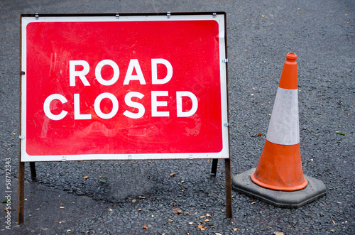 Road closed sign with traffic cone