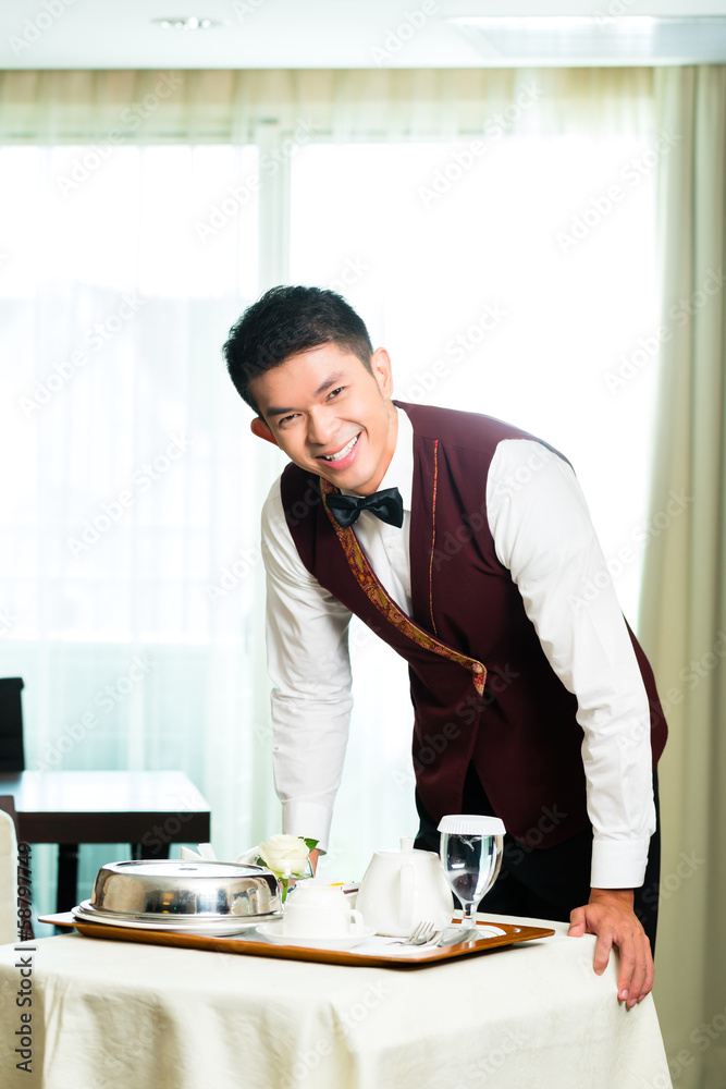 Asian Chinese room service waiter serving food in hotel Asian Chinese room service waiter serving food in hotel