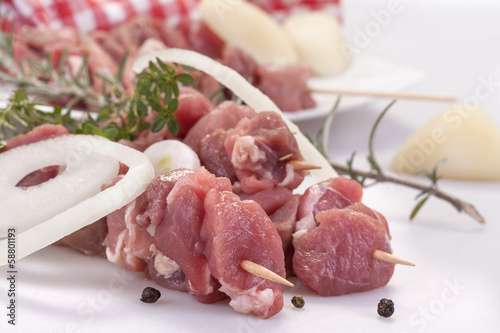 fresh pork skewers with vegetables, onions and rosemary