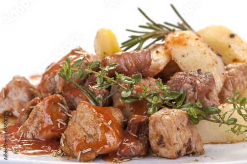 fresh roast pork in sauce with rosemary and potatoes