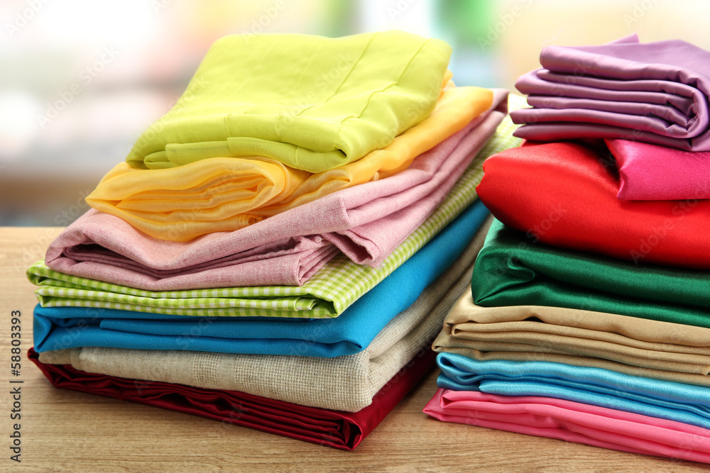 heap of cloth fabrics on wooden table heap of cloth fabrics on wooden table