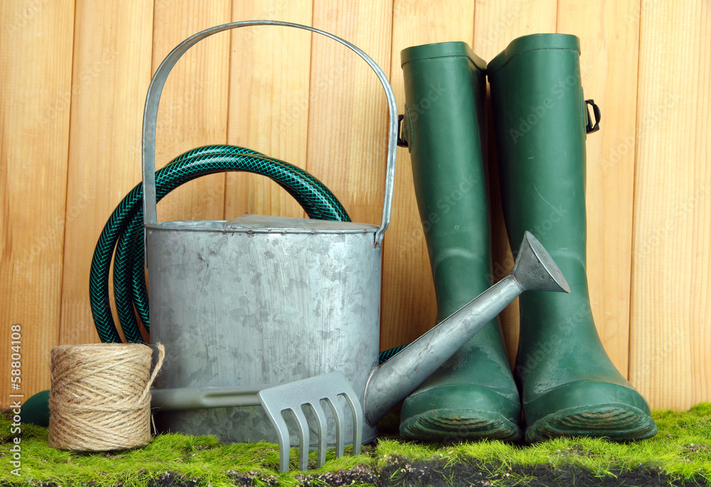 Gardening tools on grass on wooden background Gardening tools on grass on wooden background