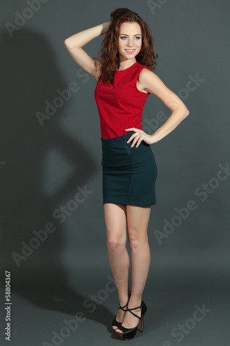 Beautiful young girl in dress on grey background