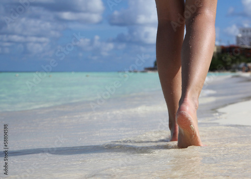 Sexy Legs on Tropical Sand Beach with footprints. Walking Female
