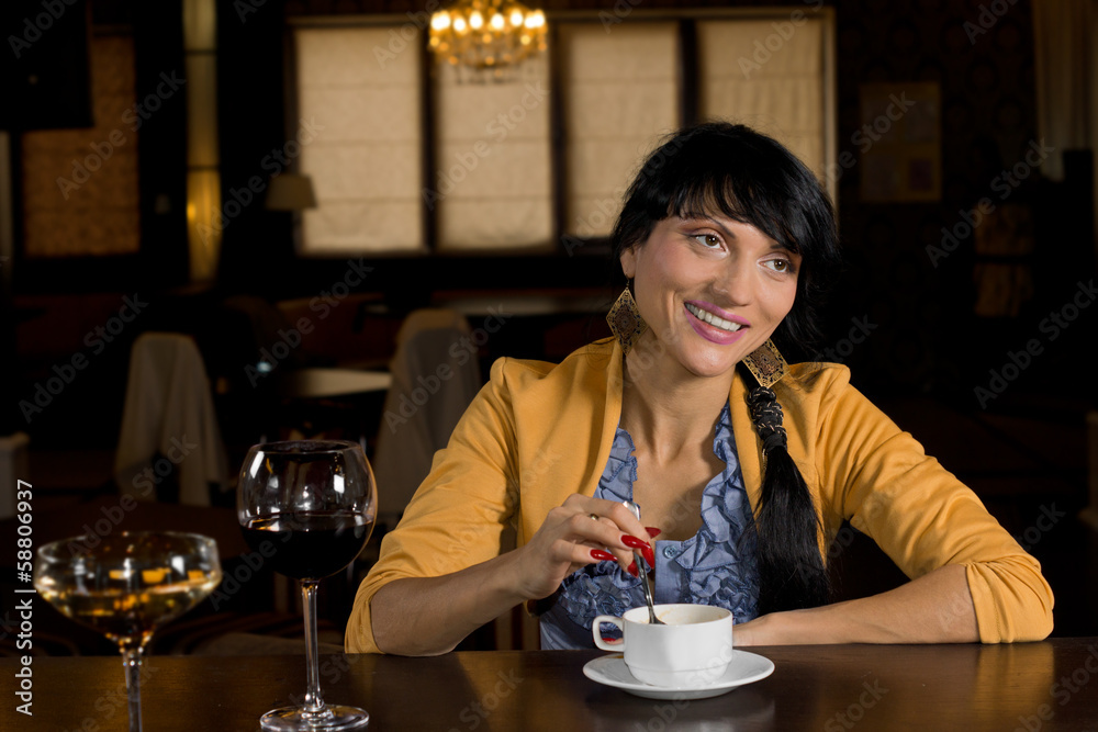 Smiling woman enjoying coffee at the bar