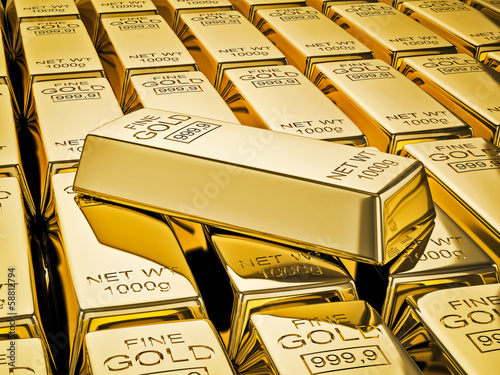 Gold bar on stacks of gold bullions close up