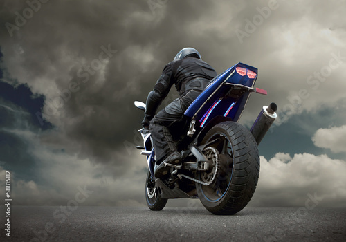 Fototapeta Naklejka Na Ścianę i Meble -  Man seat on the motorcycle under sky with clouds