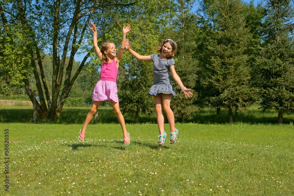 Children, girls laughing while having fun in a meadow