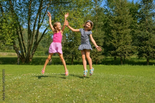 Children, girls laughing while having fun in a meadow