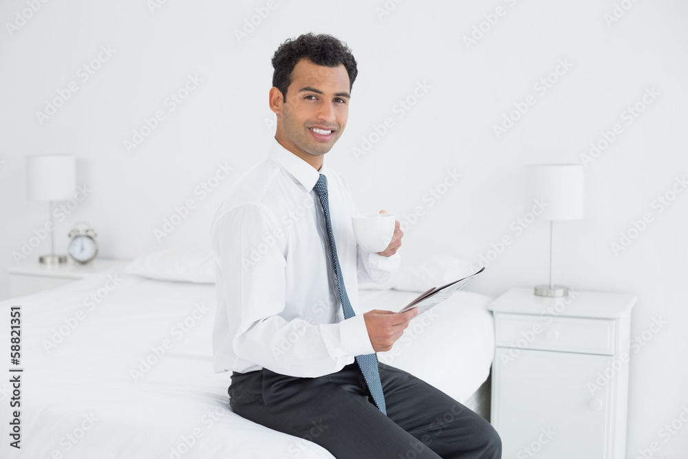 Businessman with cup reading newspaper at hotel room