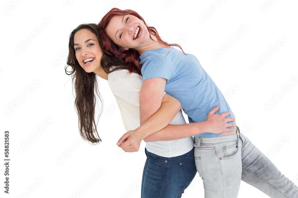 Portrait of a young woman carrying female friend on back Portrait of a young woman carrying female friend on back