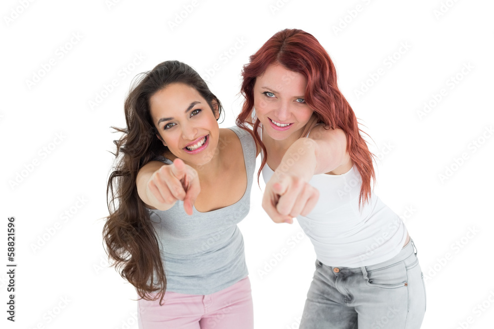 Happy young friends pointing against white background Happy young friends pointing against white background
