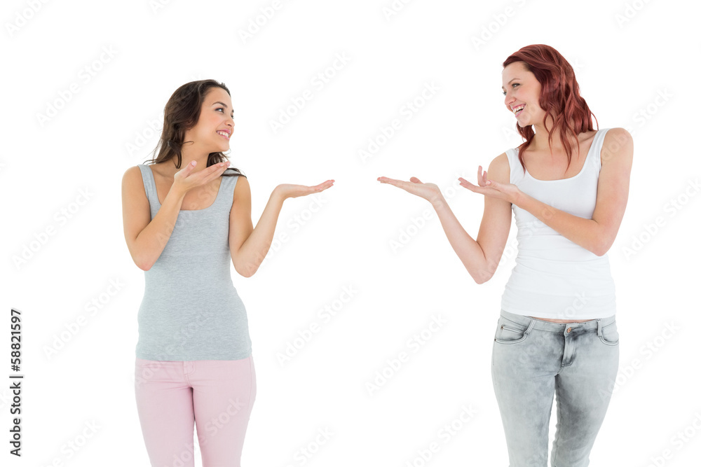 Two happy young female friends holding out their hands Two happy young female friends holding out their hands