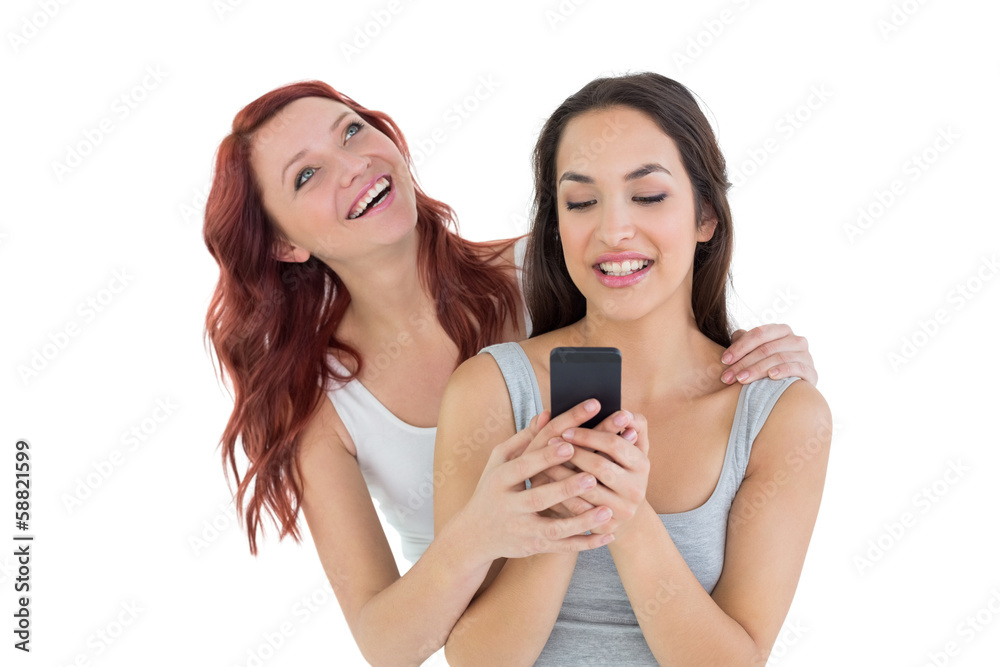 Smiling young female friends with mobile phone Smiling young female friends with mobile phone