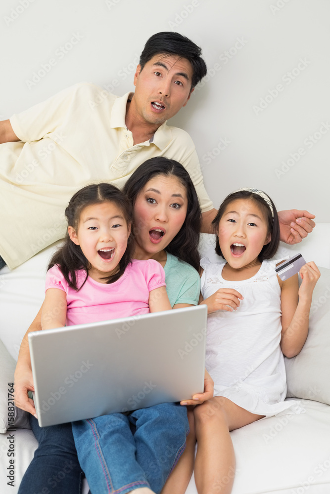 Portrait of shocked family of four doing online shopping Portrait of shocked family of four doing online shopping