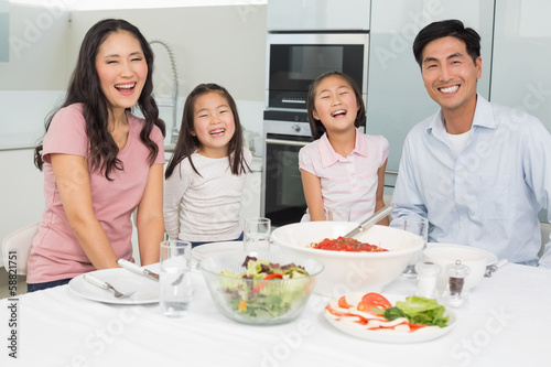Portrait of a smiling family sitting at dining table in kitchen