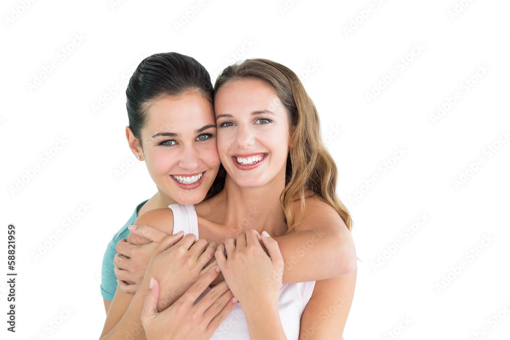 Happy female embracing her friend from behind Happy female embracing her friend from behind