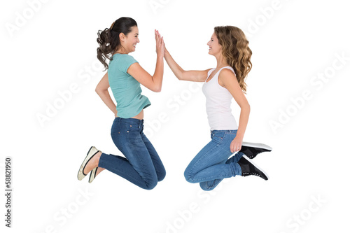 Young female friends playing clapping game