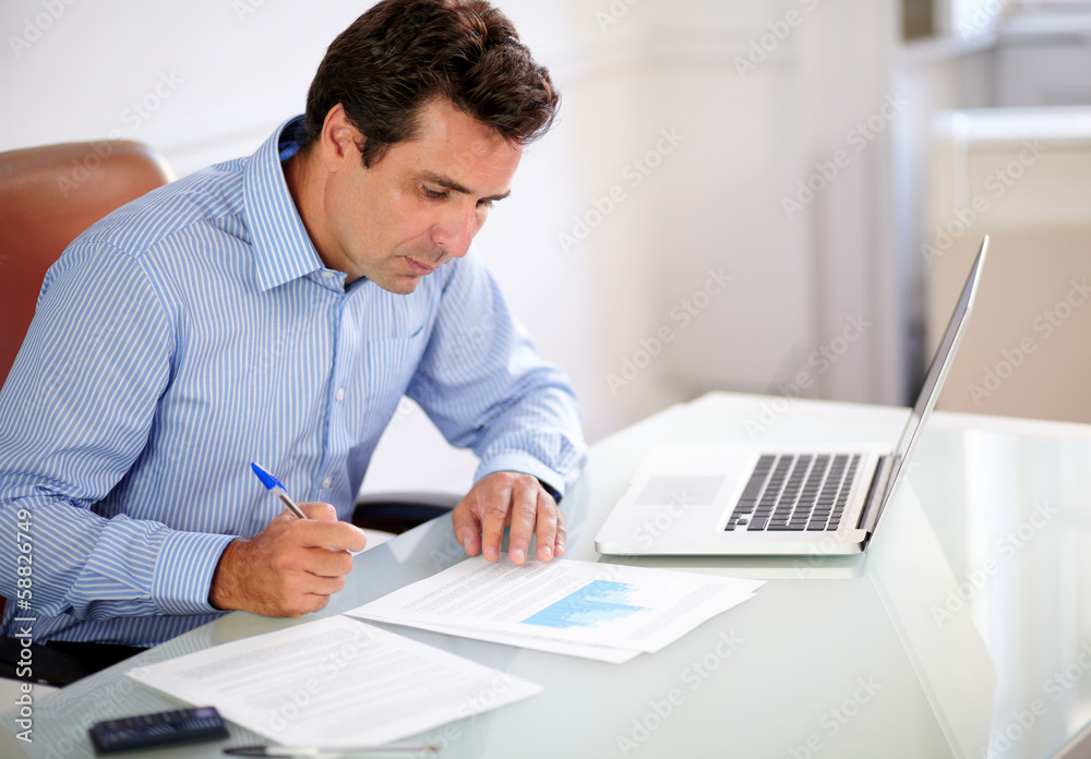 Adult hispanic businessman looking at his notes