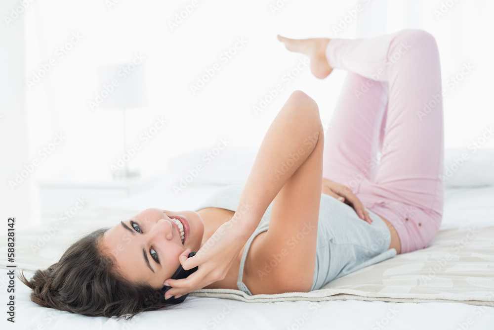 Woman in nightwear using mobile phone in bed Woman in nightwear using mobile phone in bed