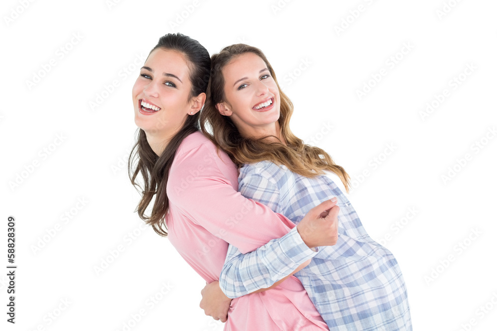 Young woman carrying female friend on back Young woman carrying female friend on back