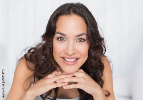 Fototapeta Naklejka Na Ścianę i Meble -  Close-up of a smiling pretty brunette in bed