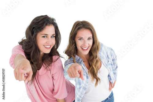 Female friends pointing against white background