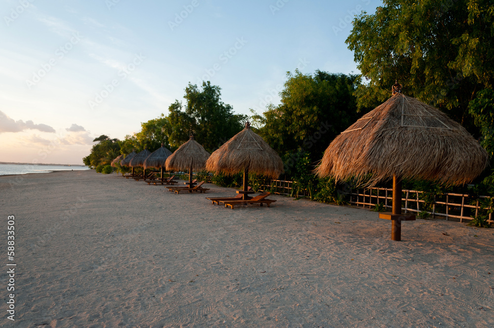 Beautiful beach with umbrella at the sunset