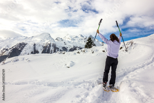 Ragazza in ciaspole con braccia in alto