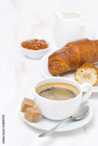 cup of black coffee and croissants with orange jam
