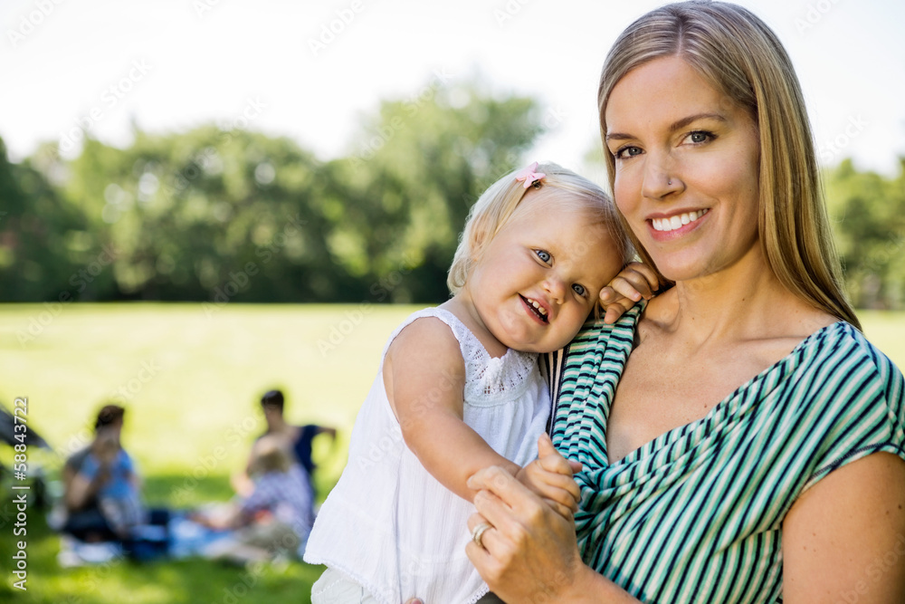 Naklejka premium Happy Mother Carrying Cute Daughter In Park
