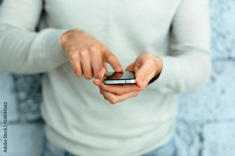 Closeup image of a male hand holding smartphone Closeup image of a male hand holding smartphone