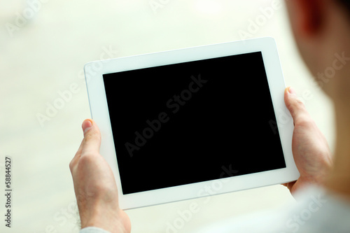 Closeup image of male hands showing screen of tablet computer