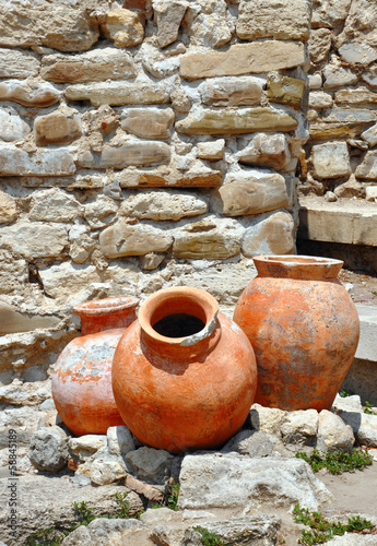 ancient amphorae on the backdrop of a stone wall