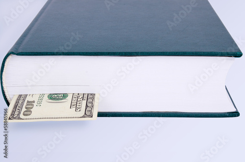 closed green book with a bookmark 100 USD