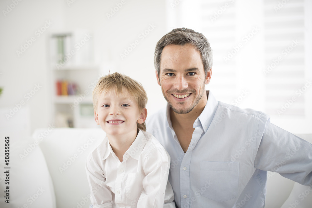 Father and his young son smiling on a couch Father and his young son smiling on a couch