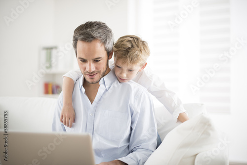father and son playing on a computer
