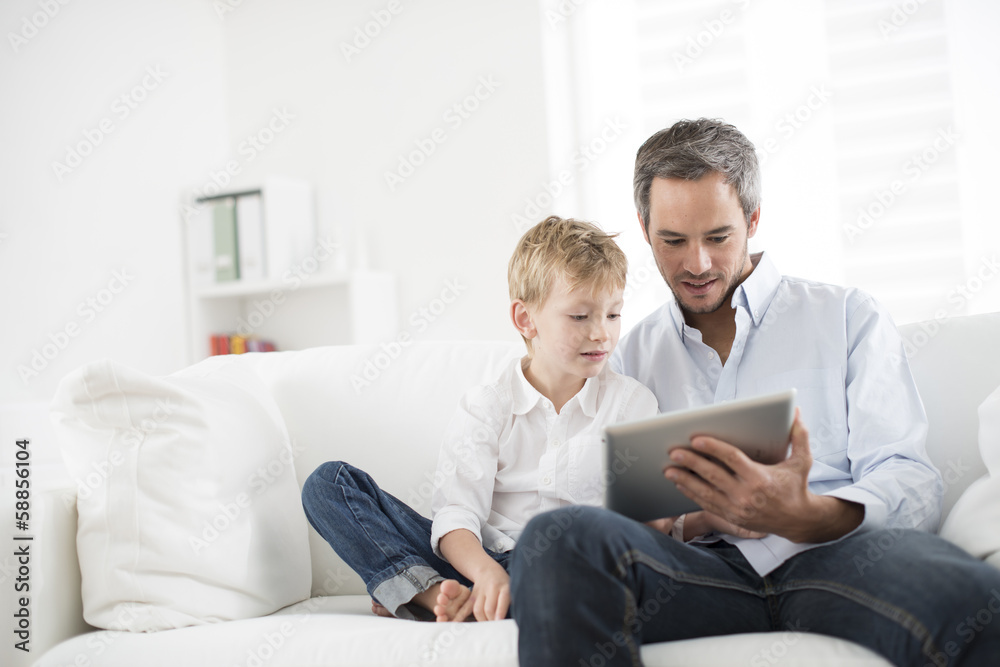 father and son playing on a tablet