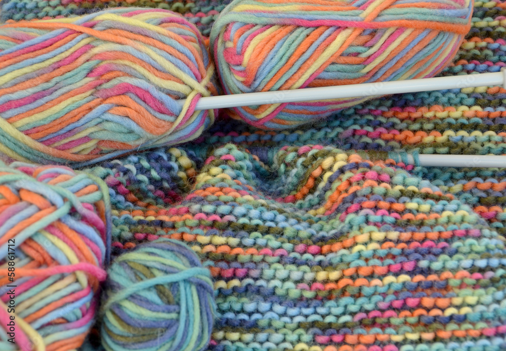 Tejido de lana en varios colores con ovillos y agujas