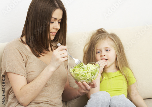 Mother feeds little girl